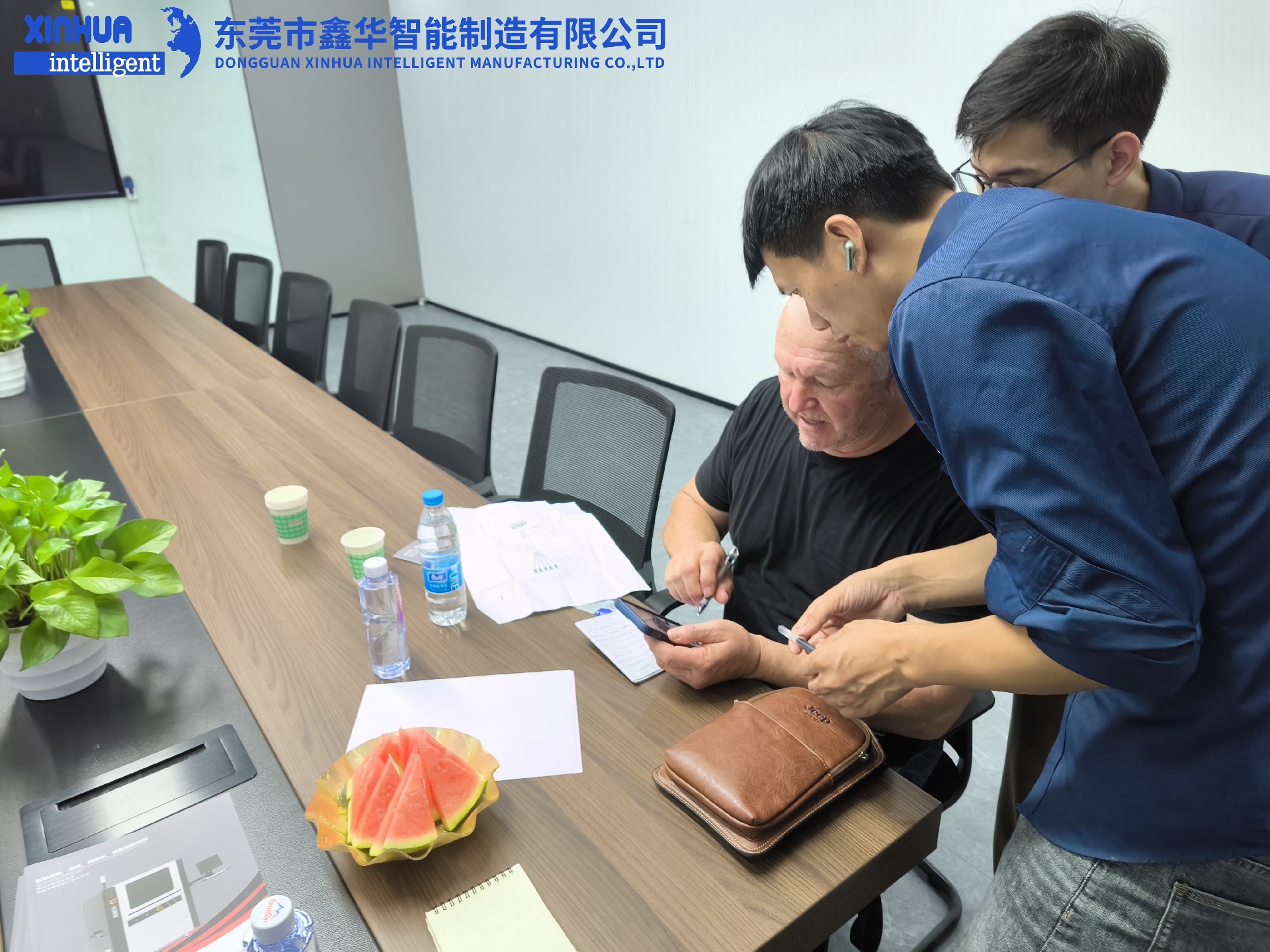 業(yè)務(wù)部2位男同事在給美國客戶耐心介紹自動(dòng)鎖螺絲機(jī)性能